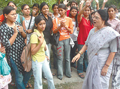 Delhi University students stands outside the NCW office while Chairperson of NCW, Girja Vyas on the way to her office , demanding immediate actions to ensure the safety of female students in the Delhi University campus, in New Delhi on Friday.