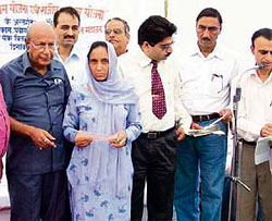 The rural development and panchayati raj minister Sat Mahajan disburses cheques under Indira and Rajiv Awas schemes at Nurpur on Saturday.