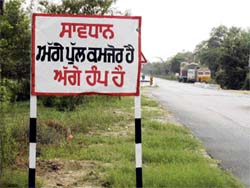 A signboard near a dilapidated bridge on the Ludhiana-Moga G.T.Road at Chowkiman.