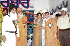 Khwaja Rashid Faridi Sabri, the 25th descendant of Sufi saint Baba Sheikh Farid lineage, presents Kiran Bedi with the Baba Farid award for honesty in Faridkot on Sunday.
