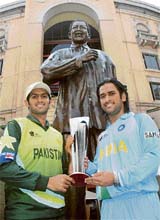 Indian captain Mahendra Singh Dhoni (right) and Pakistan skipper Shoaib Malik hold the Twenty20 World Cup trophy in front of a statue of Nelson Mandela in Johannesburg 