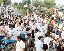 Farmers block NH-1 in Karnal on Wednesday in protest against the non-procurement of their paddy crop.