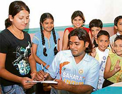 Anil Rewri, who resembles cricketer Mahendra Singh Dhoni, signs his autograph in Karnal on Friday.
