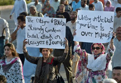Pakistani human rights activists hold placards as they march with journalists towards the Presidency during a protest in Islamabad on Sunday.