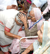 Chief Minister Sheila Dikshit seeks blessings of a centenarian lady after presenting the identity card to her at a function in the Delhi Secretariat on Monday.