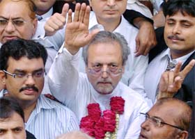 Former Pakistan Supreme Court Judge Wajihud Din Ahmed (centre), who has been nominated by anti-Musharraf lawyers for the upcoming presidential election, waves as he arrives at the Sindh High Court in Karachi