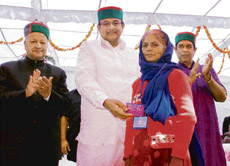 Union finance minister P. Chidambaram (centre) hands over the Aam Aadmi Bima Yojna card to a woman beneficiary during the launching of the scheme at Simla on Tuesday as Chief Minister Virbhdra Singh and union minister of state for labour and employment Oscar Fernandes clap