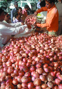 People buy onion from a government stall in front of Delhi Secretariat in the Capital on Wednesday.