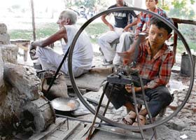 Eight-year-old Akshay Kumar works in an ironsmith's shop in Uchana village in Karnal