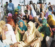 Villagers block a road leading to Shergarh Tapoo village in Karnal district in protest against the police action against them on Saturday