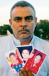 Pawan Kumar shows photographs of his wife, daughter and son, who have allegedly been kidnapped.