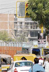 The traffic light on Bharat Nagar chowk is covered by a tree, making it difficult for drivers to see the light.