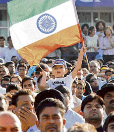 A little fan holds the tricolour as spectators look on anxiously.