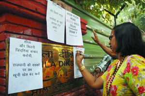 A member of resident welfare association signs a paper during a protest against killing of eight persons by a Blueline bus and also demand Delhi Chief Minister Sheila Dikshit and state transport minister Haroon Yusuf's resignation, outside CM residence in the Capital on Monday