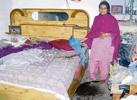 A woman shows the ransacked house where burglars struck terror last night