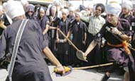 Students of the Miri Piri Academy play gatka during the procession
