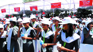 Schoolchildren brush their teeth, as they participate in an event of Colgate-Palmolive (India) Limited to break a Guinness World Record in the Capital on Tuesday