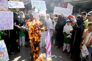 Muslim activists of Jamat-ul-Islamia burn the effigy of US President George W. Bush and raise anti-US slogans in protest against the construction of an office of the Apple Corporation which is a replica of Mecca