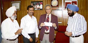 Officials of United Breweries Ltd hand over a cheque for Rs 4.47 lakh as the first instalment to PAU vice-chancellor M.S. Kang for conducting a joint research on malt barley in Punjab