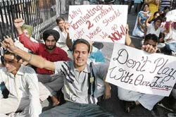 NRI quota students of MBA and MCA courses of Guru Nanak Dev University protest against the authorities at the main gate of the university