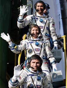 Malaysian astronaut Sheikh Muszaphar (top), Russian cosmonaut Yuri Malenchenko (bottom) and US astronaut Peggy Whitson wave before boarding a space capsule at the Baikonur cosmodrome in Kazakhstan