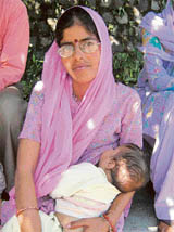 A woman complainant with an infant awaits her turn for appearing before the Kangra ADC, who is probing anganwari selections, at Kangra on Thursday.
