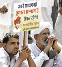 Protesters from the ethnic Gujjar community wave placards during a rally to demand Scheduled Caste and Scheduled Tribe status for them at Jantar Mantar in New Delhi on Thursday.