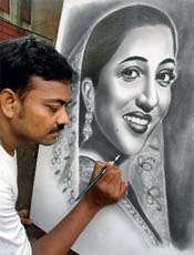 Pavement artist Ramjan Hussain gives final touches on a pencil sketch of legendary actress Suchitra Sen at a pavement as a part of his wishes for her immediate recovery in Kolkata on Thursday.