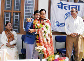 Chetna general secretary Mallika Nadda hugs mentally challenged sportsman Vikram Chauhan after honouring him at Bilaspur. Chauhan won the gold medal in volleyball during the International Special Olympics in Shanghai.