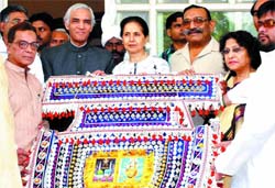Delhi Lt-Governor Tejendra Khanna and Uma Khanna receive the traditional Pankha from office-bearers of Anjuman Sair-e-Gulfaroshan at Raj Niwas in the Capital on Wednesday.