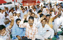 Members of the Haryana State Fourth Class Government Employees Union stage a protest against the government for not raising their salaries opposite the mini secretariat in Karnal on Wednesday. 