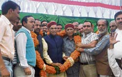 Workers of the Nachan block of the BJP garland former Chief Minister Prem Kumar Dhumal , state unit chief Jai Ram and former minister Dile Ram during an election rally at Kanaid, near Sundernagar, on Thursday.