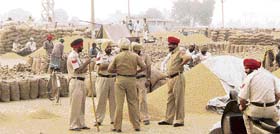 Policemen keep a watch on the situation at the Kup purchase centre near Ahmedgarh