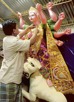 An artisan gives finishing touches to an idol of Durga as the city prepares to celebrates Dasehra on Sunday.