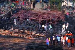 Devotees clear up the gutted Durga Puja Pandal at CR Park in the Capital on Friday. 
