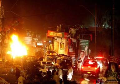 Supporters of Benazir Bhutto climb down from her open-air truck after a bomb explosion at a procession of Pakistans former Prime Minister in Karachi on Thursday.