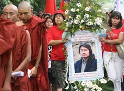 Buddhist monks lead a procession as a portrait of fallen Japanese photojournalist Kenji Nagai, killed on September 27, 2006, while covering a violent crackdown on pro-democracy supporters on the streets of Yangon, is paraded in Kuala Lumpur on Friday