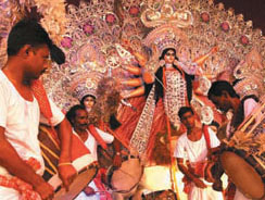 Artistes perform in front of an idol of Goddess Durga at a Durga Puja pandal in the Capital on Saturday.
