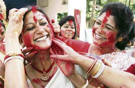 Women daub each other with vermillion at the end of the Durga Puja in Indore