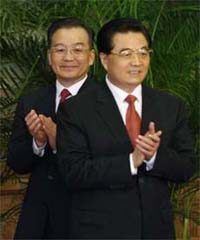 China's President Hu Jintao (right) and Premier Wen Jiabao clap during a meeting between the new Politburo Standing Committee members and the media at the Great Hall of the People in Beijing