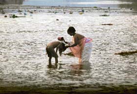 A woman bathes her child in the Sutlej on a dusky Tuesday evening in Ludhiana