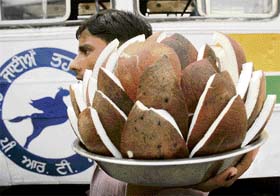 A vendor sells cut pieces of coconut at the bus stand in Patiala