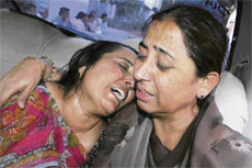 Chandrikaben Tanna, mother of Milan Tanna, is consoled by a close relative outside the post mortem room at Vadilal Sarabhai Hospital in Ahmedabad on Thursday.