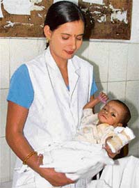 A nurse holds a four-month-old girl child, who was abandoned by her parents, at the Civil Hospital in Gurgaon
