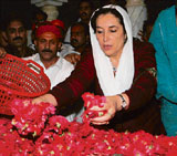 Former Pakistan Prime Minister Benazir Bhutto lays flowers at the grave of her father Zulfikar Ali Bhutto in Garhi Khuda Bux near Larkana, 480 km from Karachi, on Saturday.