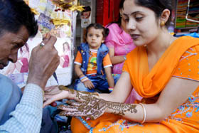 A woman gets henna applied on her hands on the eve of Karva Chauth in Jammu on Sunday. 