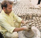 Jagdish, a potter, makes earthen lamps for Diwali in Karnal.