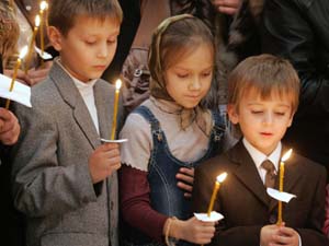 Children hold candles during a memorial service in Moscow