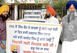 Sikh radicals outside the district courts with posters demanding arrest of perpetrators of 1984 riots, in Chandigarh on Thursday.
