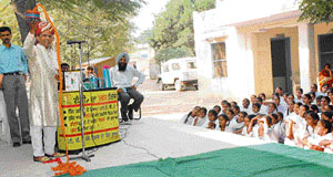 Magician Ved Parkash explains to students and others about TB through a magic trick on the campus of a government school at Ubhawal village, near Sangrur.